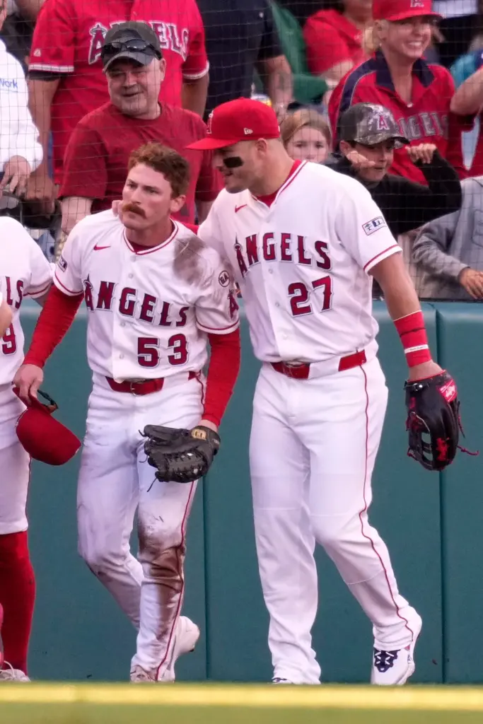 Angels left fielder Wade Meckler, left, gets a pat on...