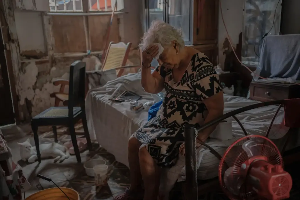 FILE – Margarita Salazar, 82, wipes the sweat off with...