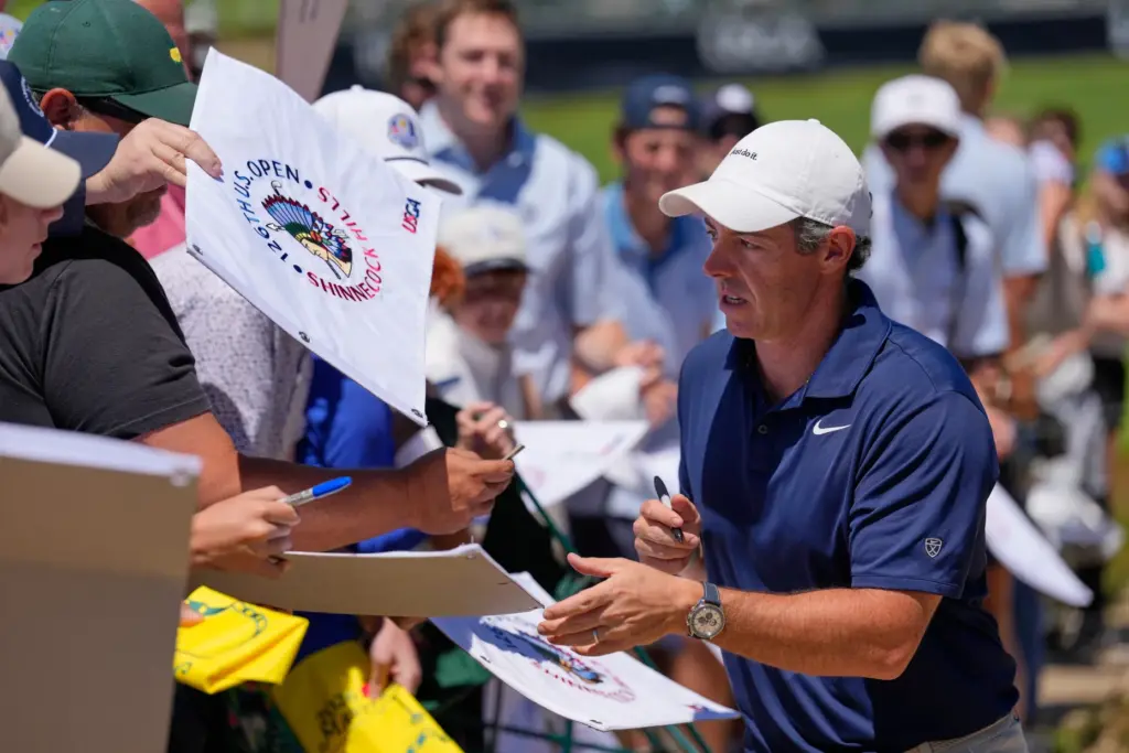 Rory McIlroy signs autographs for fans during a practice round...