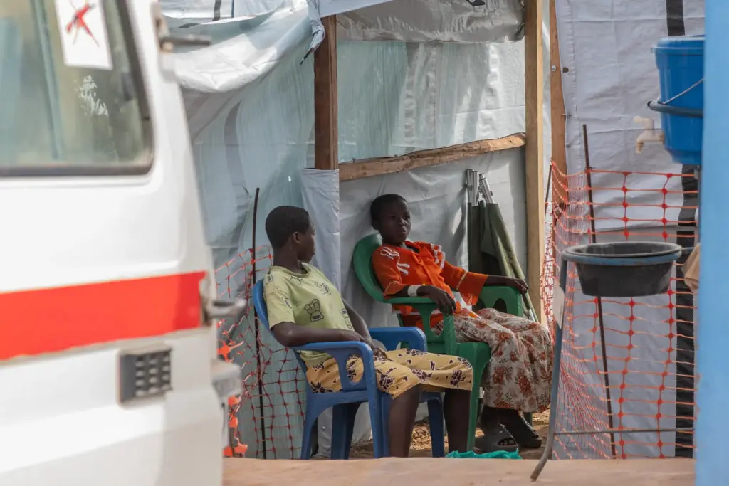 Two girls sit at the isolation center in Bunia, Congo,...