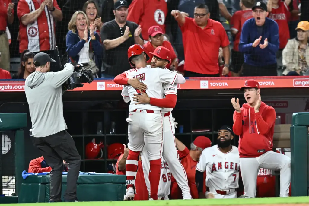 The Angels’ Zach Neto, center left, is embraced by teammate...