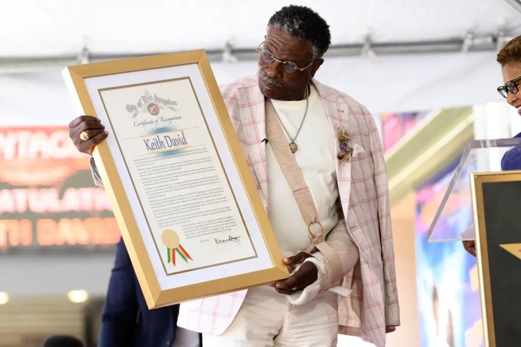 Keith David holds a certificate of recgonition signed by Mayor...