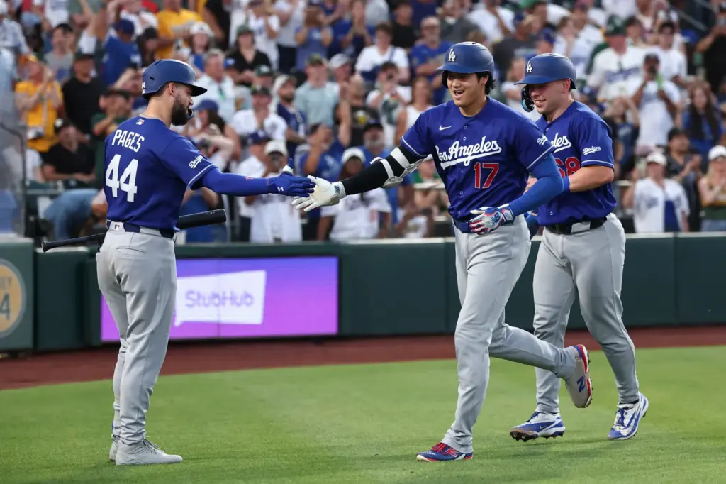 Dodgers star Shohei Ohtani high-fives teammate Andy Pages, left, after...