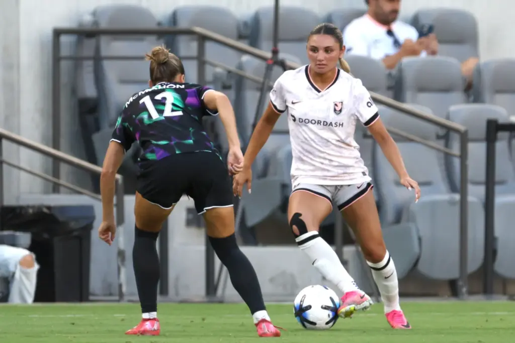 Angel City FC defender Gisele Thompson, right, controls the ball...