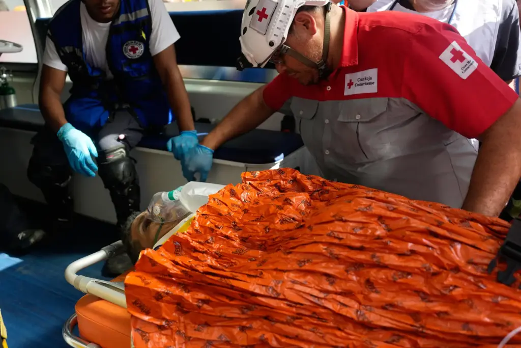 Rescue workers carry Alberto Gil after he was pulled from the rubble.