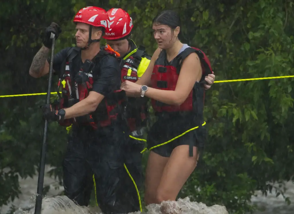 Members of the Boerne Fire Department rescue a woman from flood waters.