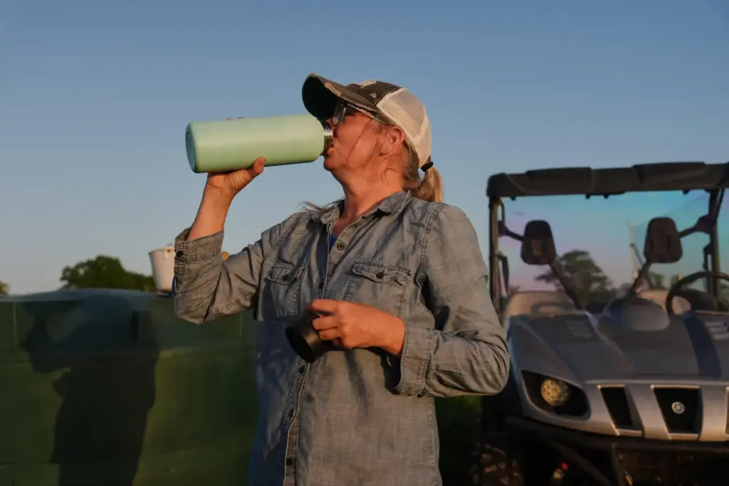 Annie Woods takes a drink of water while harvesting.