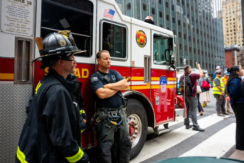Firefighters stage at the intersection of 3rd Avenue and East...