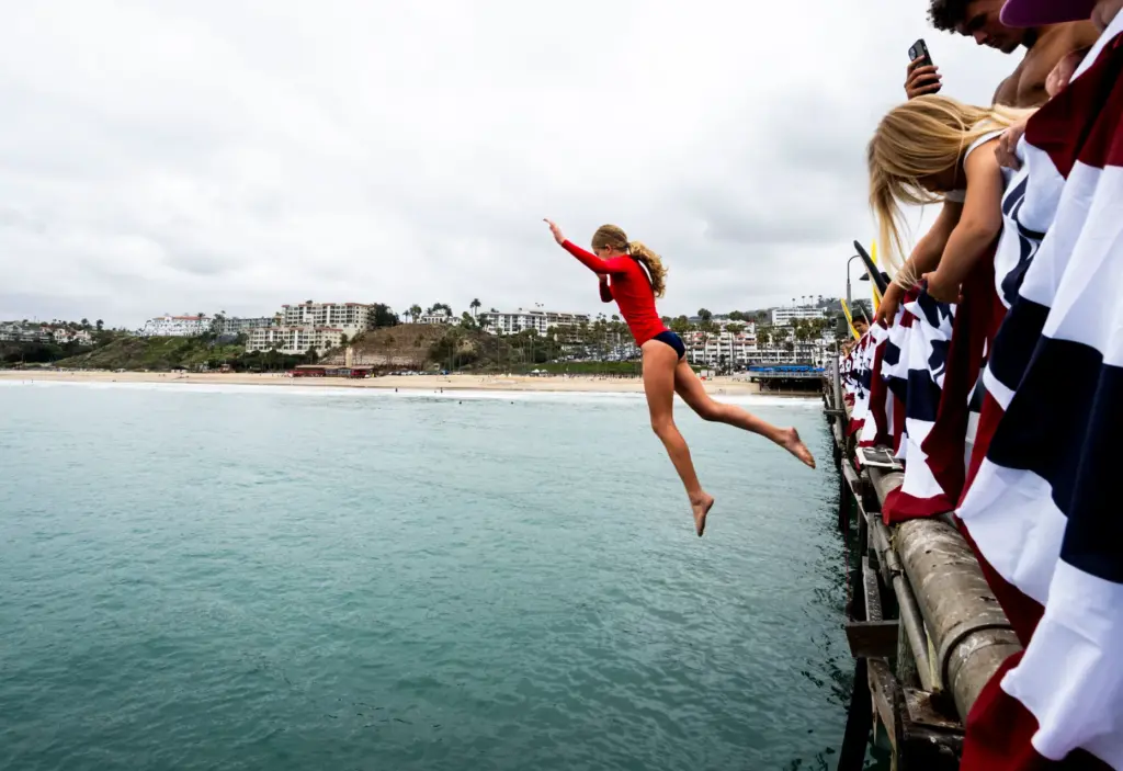 Lila Skelton jumps off the San Clemente pier as part...