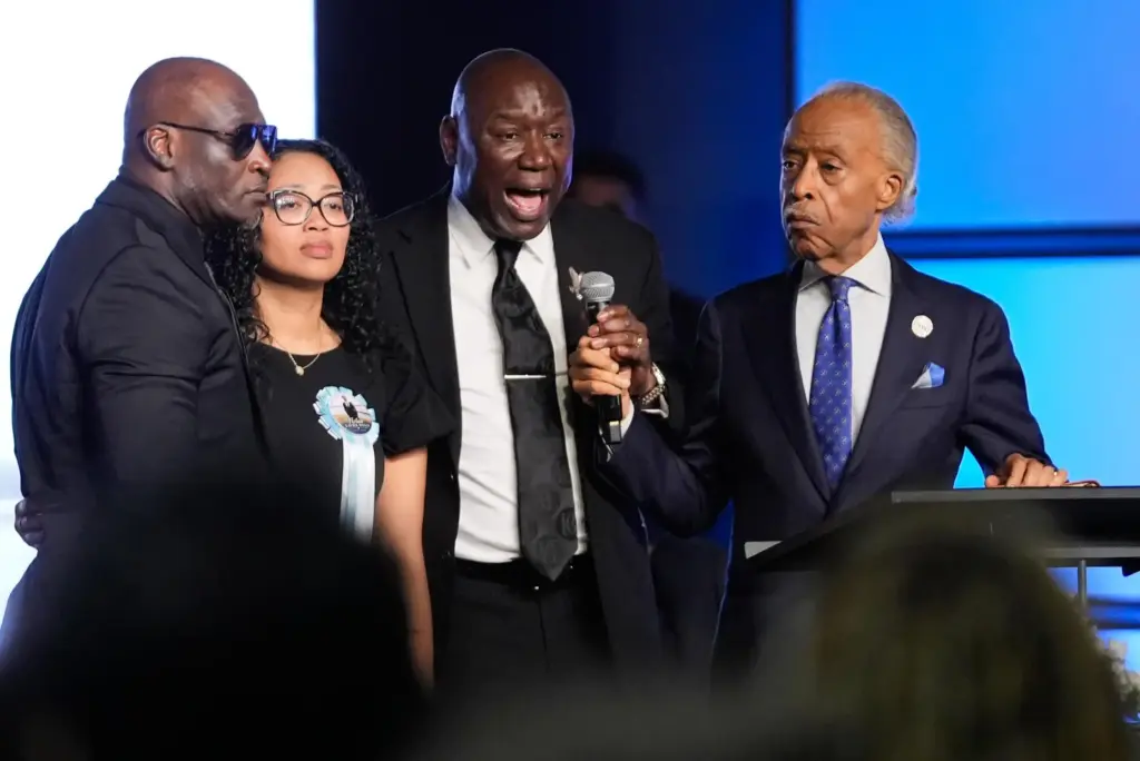 Attorney Ben Crump, center, speaks next to Elmore and Christine...