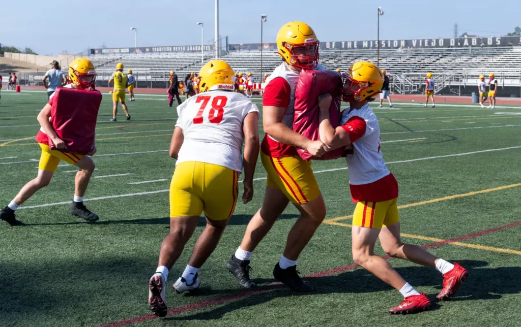 Offensive linemen run drills during practice at Mission Viejo High...