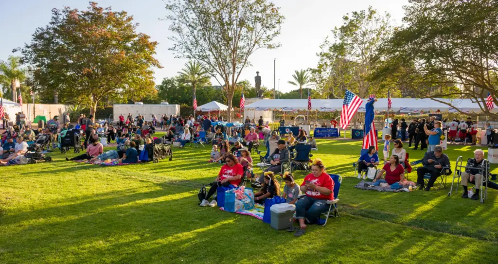 Families setup chairs and blankets on the lawn during the...