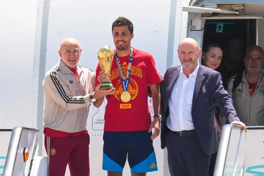 Rodrigo Hernandez holds the World Cup trophy alongside Spain head coach Luis de la Fuente.