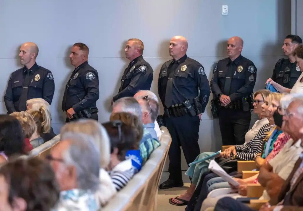 Several Newport Beach police officers stand together in the back...