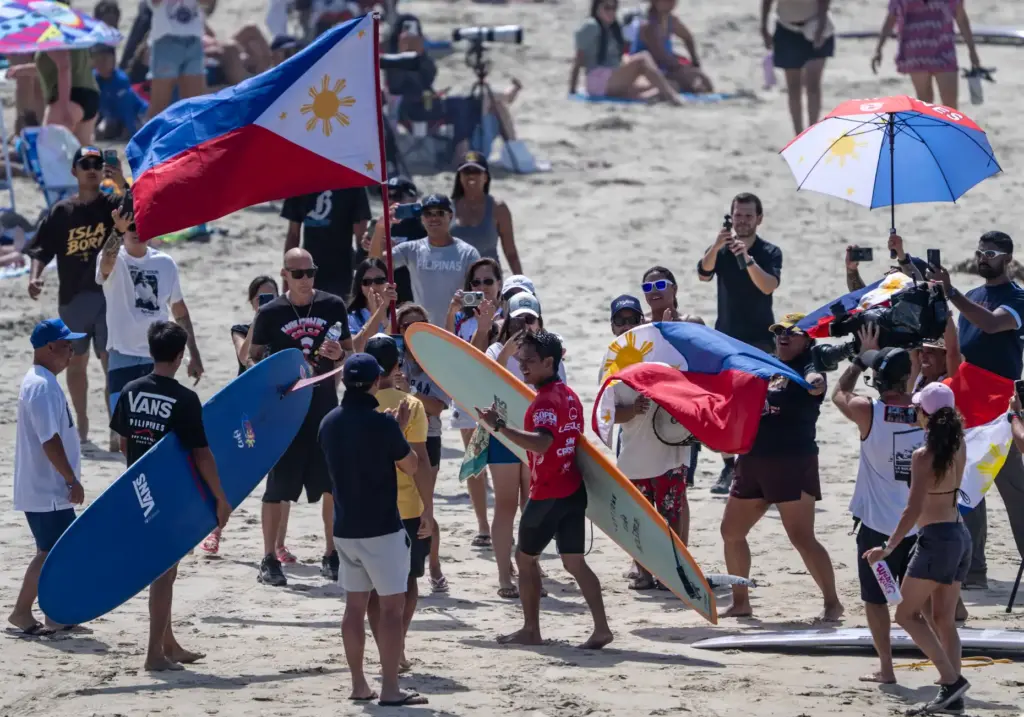 Rogelio Esquievel of the Philippines is greeted by flag-waving fans...