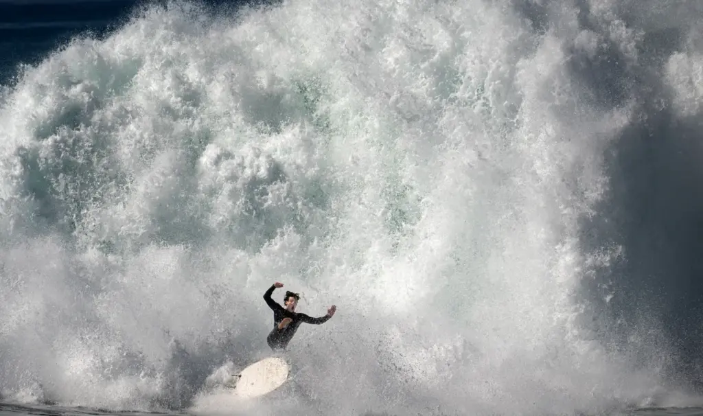 A surfer gets humbled by nature as a big swell...