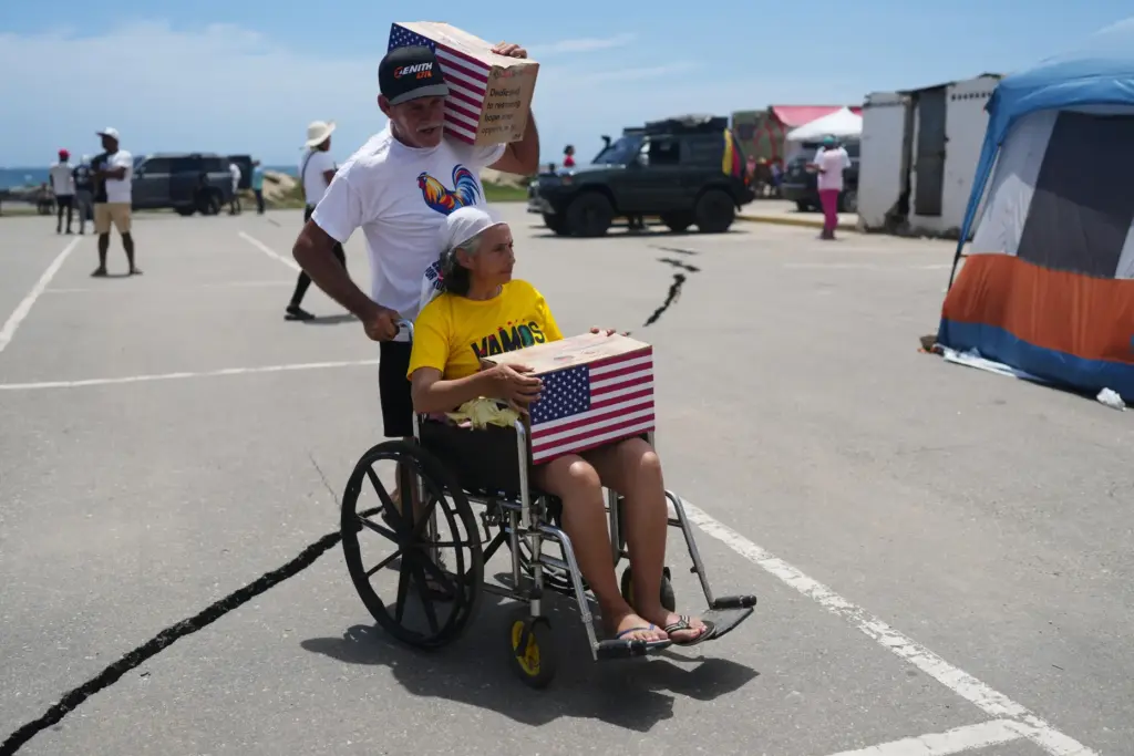 People affected by the earthquakes carry U.S. humanitarian aid.