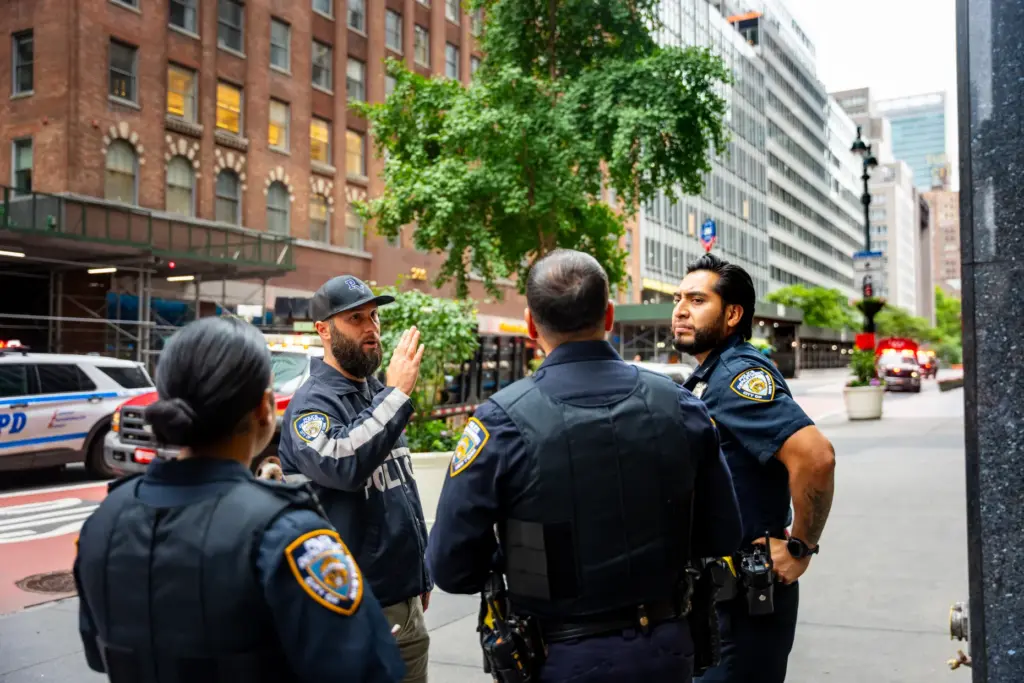 NYPD officers talk about nearby buildings that were evacuated, Tuesday,...