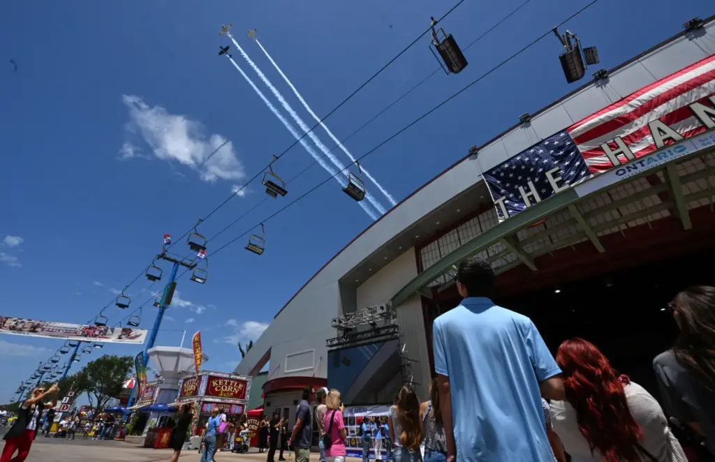 Three 1950-era Beechcraft T-34s fly over opening day at the...