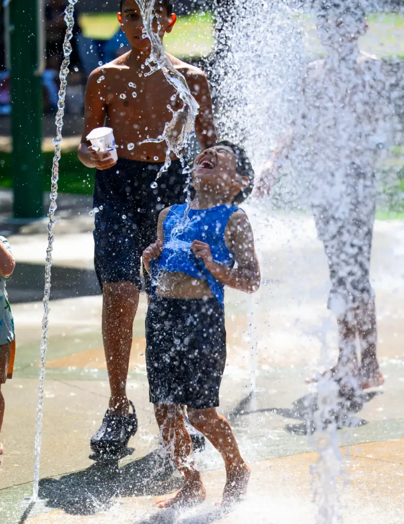 Water from the new Splash Pad at Portola Park cools...