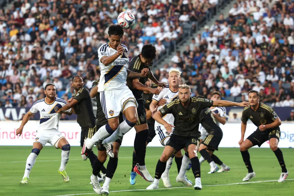 Galaxy midfielder Elijah Wynder, top, heads the ball during the...