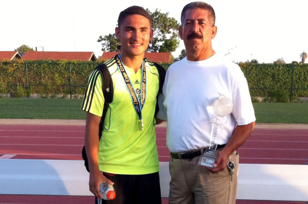 Cristian Roldan poses with childhood soccer coach Sergio Gomez of...