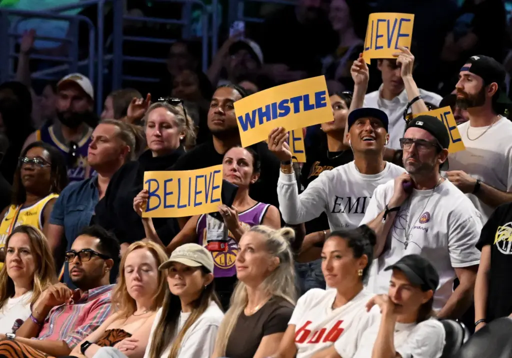 Fans hold up signs during the second half of a...
