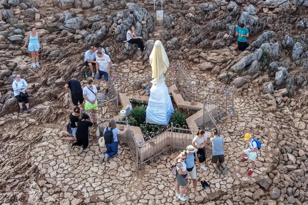 An aerial view of pilgrims praying next to the vandalized...