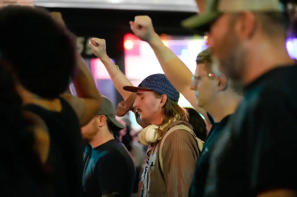 Attendees gesture during a candlelight vigil where a Madison police...