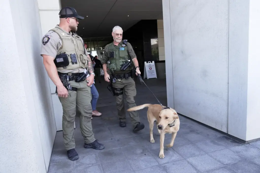 Police officials handle a dog outside a preliminary hearing for Tyler Robinson.