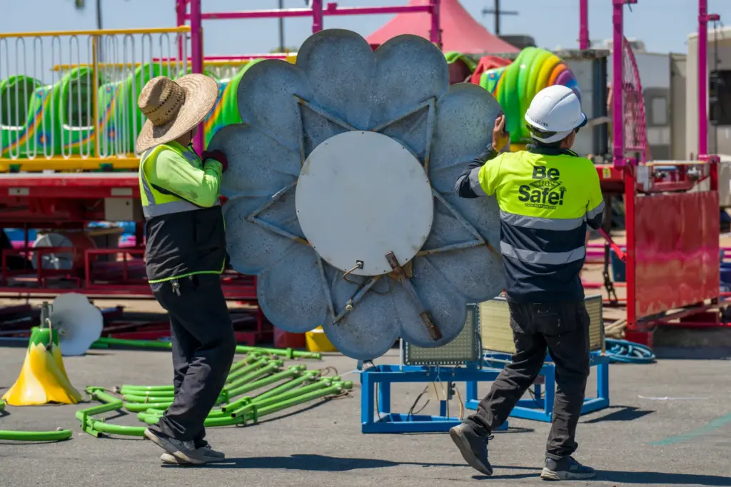 Crews carry a section of the Wiggle Wurm ride to...