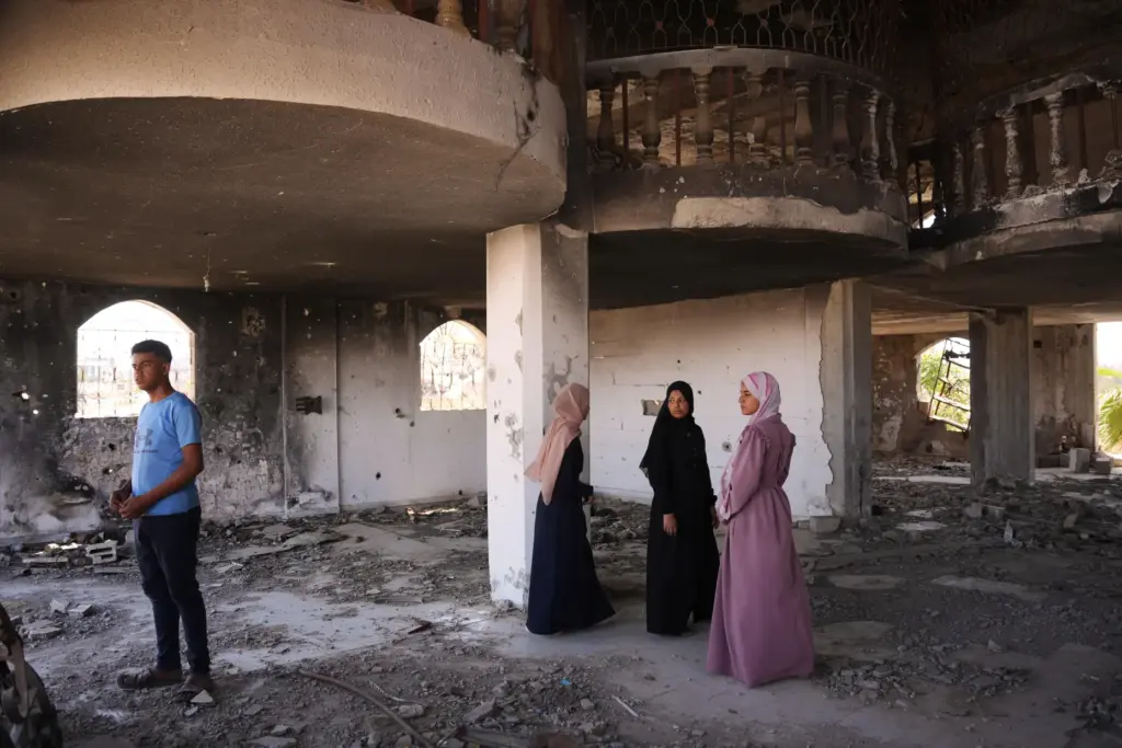 Fady al-Gharam, left, and his sisters inspect their family’s home...