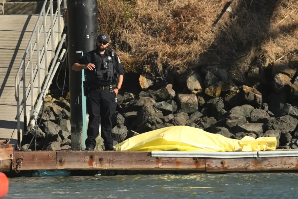 A body is covered with a tarp on a dock...