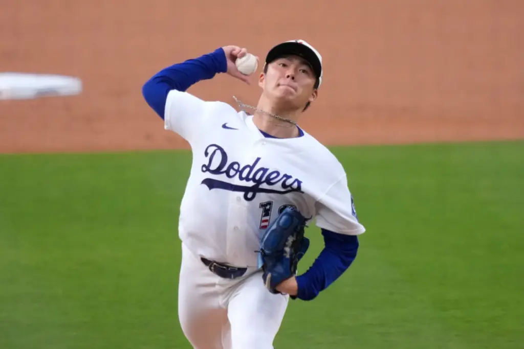 Dodgers starting pitcher Yoshinobu Yamamoto throws to the plate during...