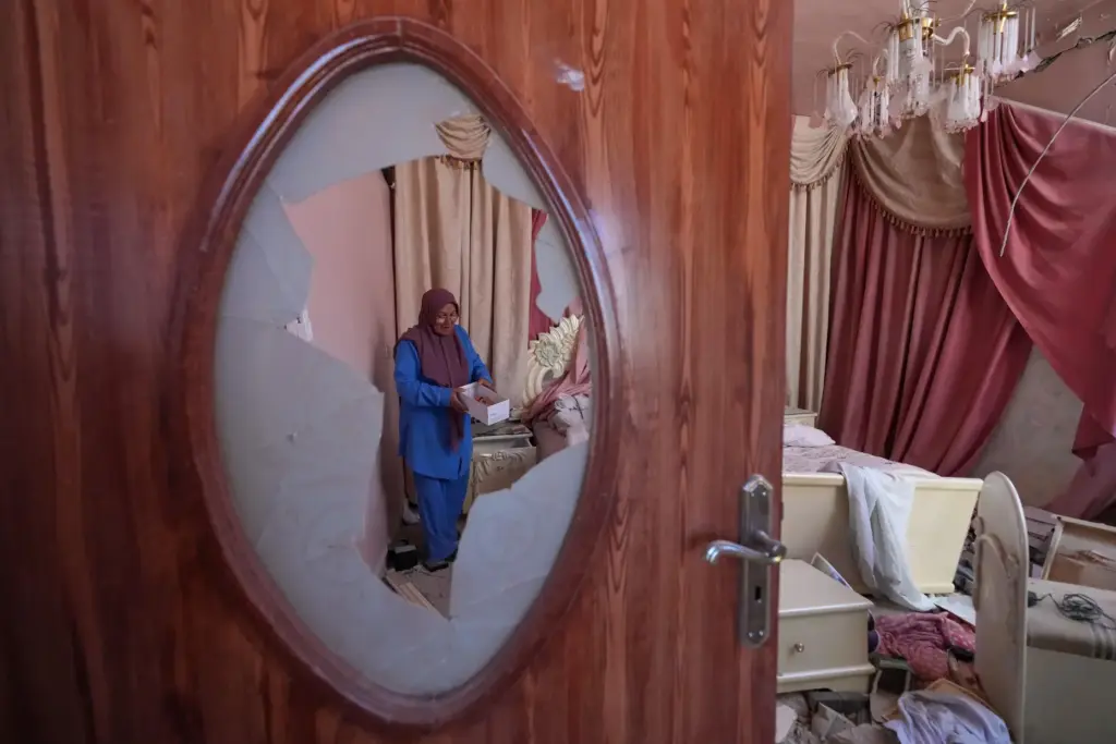 Mahasen Faqih is seen through a shattered glass door.
