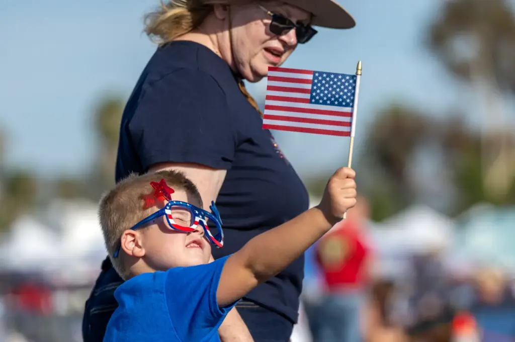 Hayden Gamblin, 4, of Costa Mesa holds out an American...