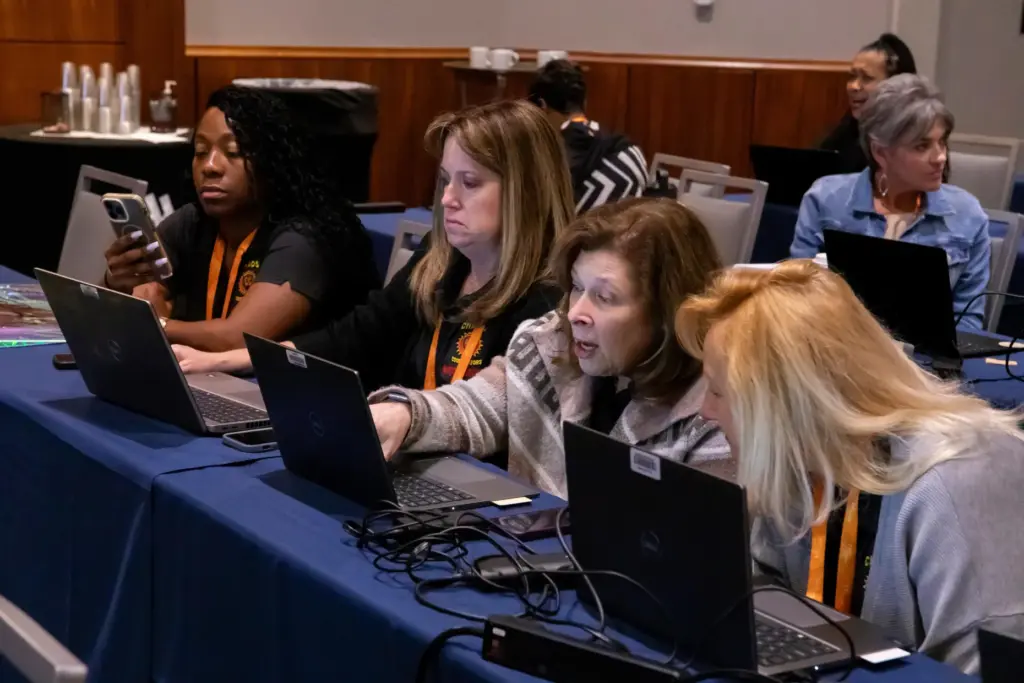 Raytheon administrators Marianna Leonard, Holly Martineau, Lynn Ljunggren and Annemarie Downing workshop an AI exercise.