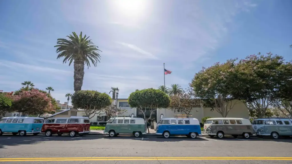 Several vintage Volkswagen busses line Main Street in front of...