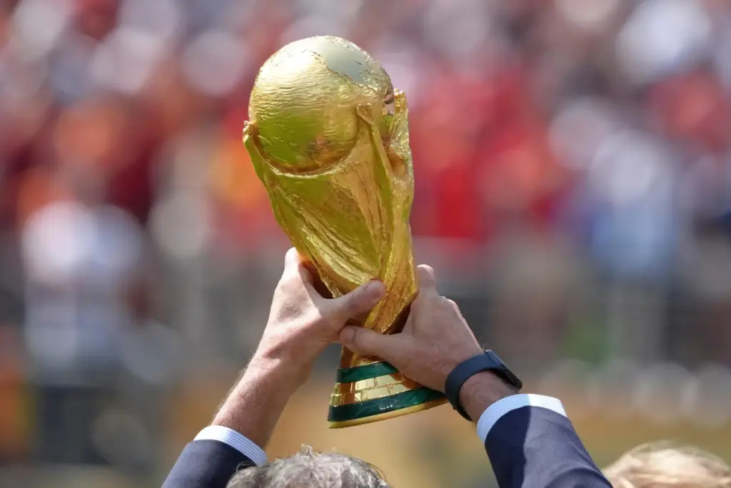 Mario Kempes holds the trophy before the start of the...