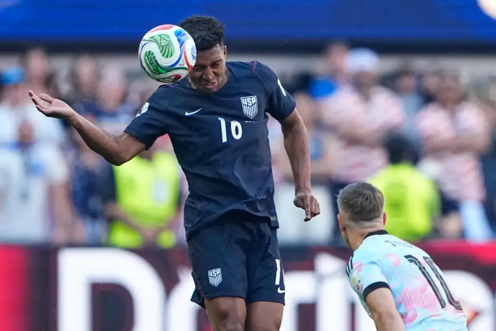 United States’ Alex Freeman (16) heads the ball away from...