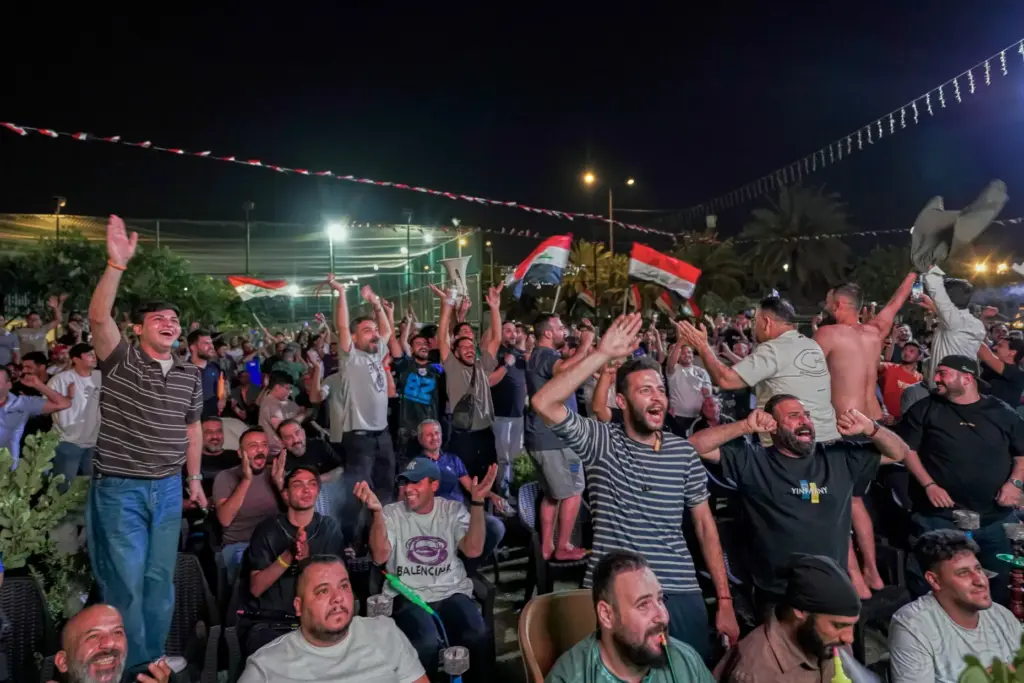 Iraqi soccer fans react as they watch the World Cup...