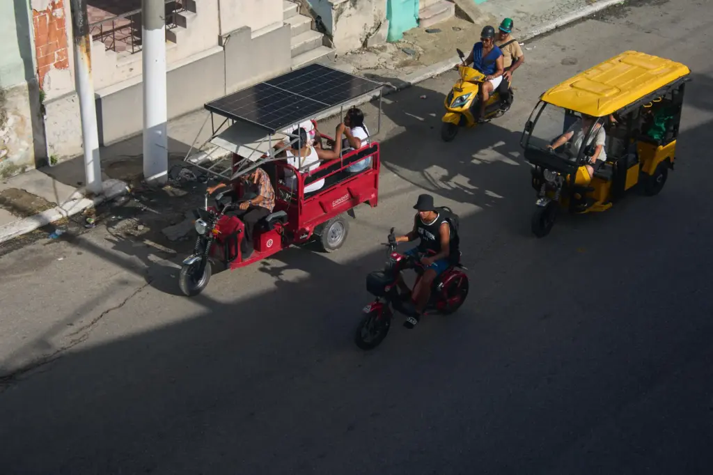 People ride in electric tricycles in Havana, Cuba, Friday, July...