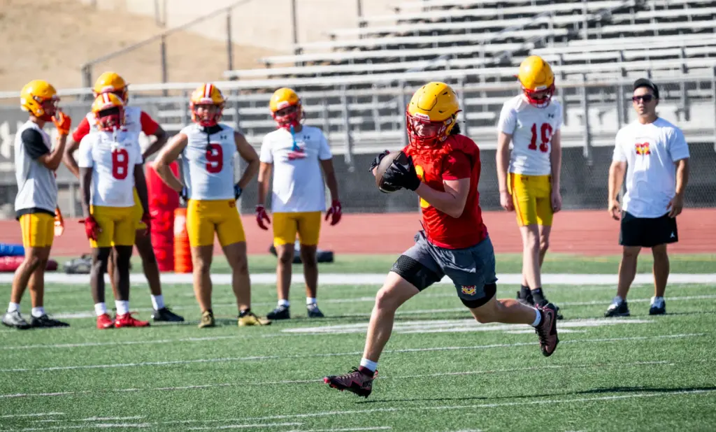 Mission Viejo High School players run plays during practice in...