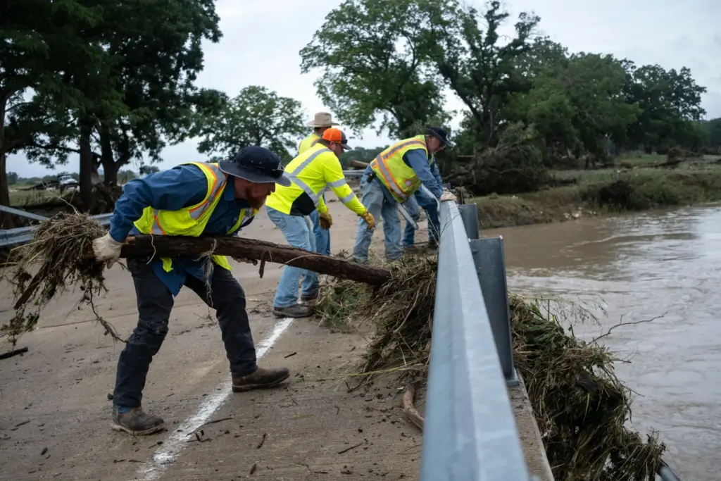 Crews clean up flood debris along the Guadalupe River on...