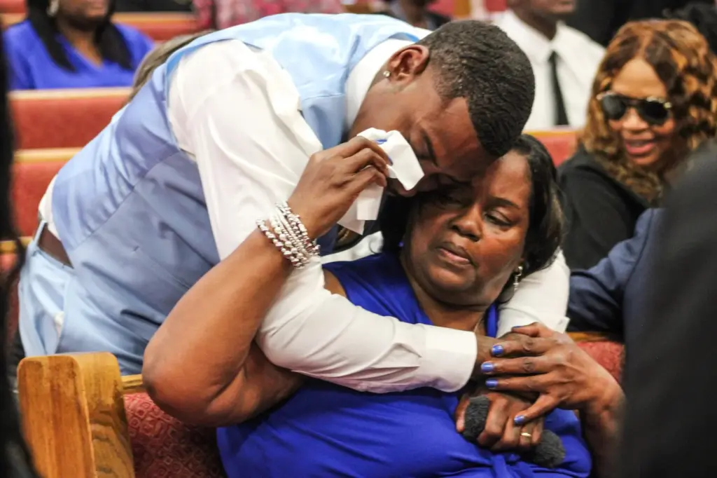 Cynthia Gilmore sits in the front row of her son Lloyd Gilmore's funeral.