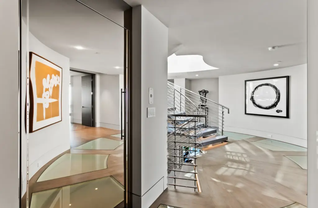 Starphire ultra-clear glass floor panels flank a central stainless-steel staircase...