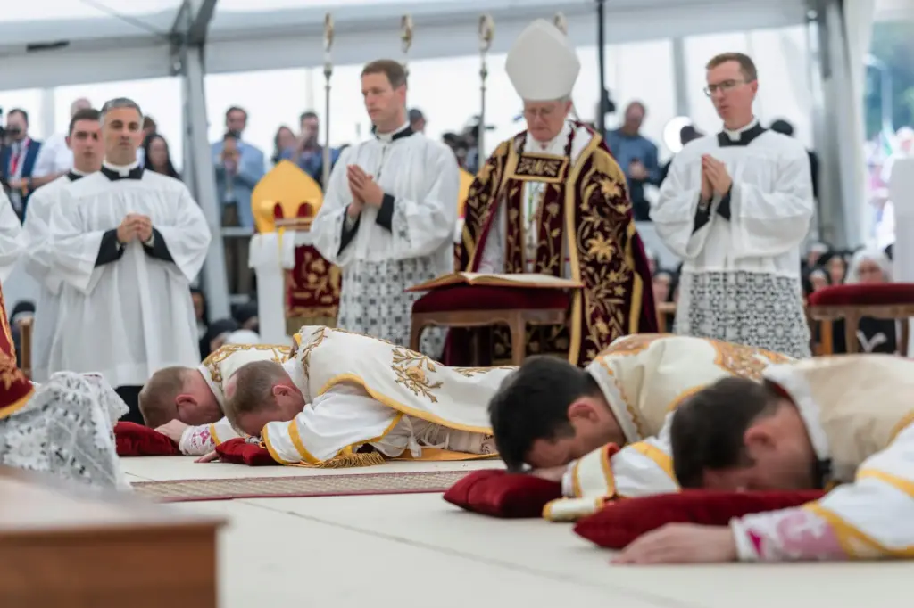 Four bishops lie on the floor as they are given episcopal consecration.