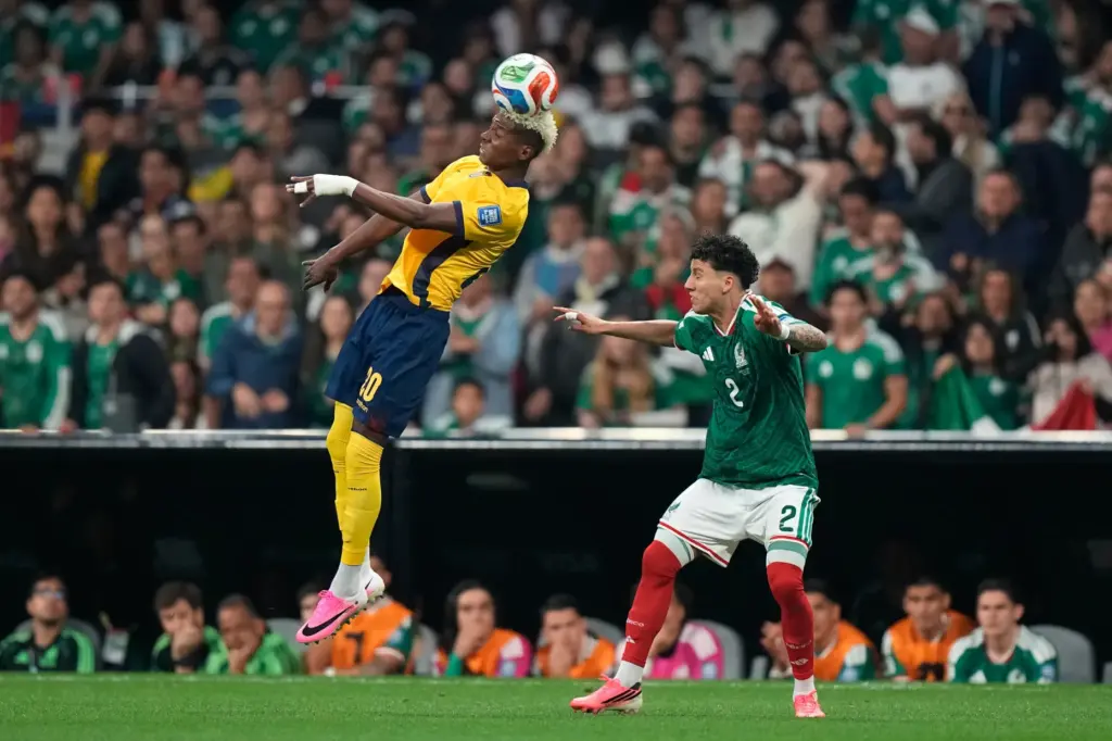 Ecuador’s Nilson Angulo (20) heads the ball over Mexico’s Jorge...