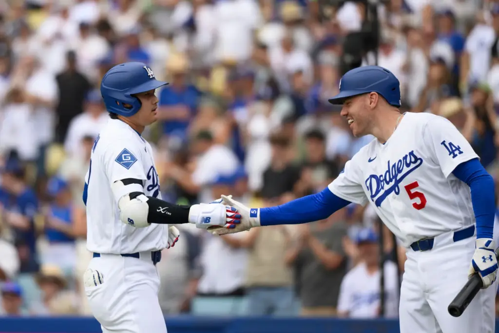 Dodgers’ Shohei Ohtani, left, celebrates after his solo home run...