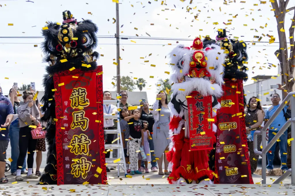 Lion dancers perform outside the library on Saturday, July 11,...